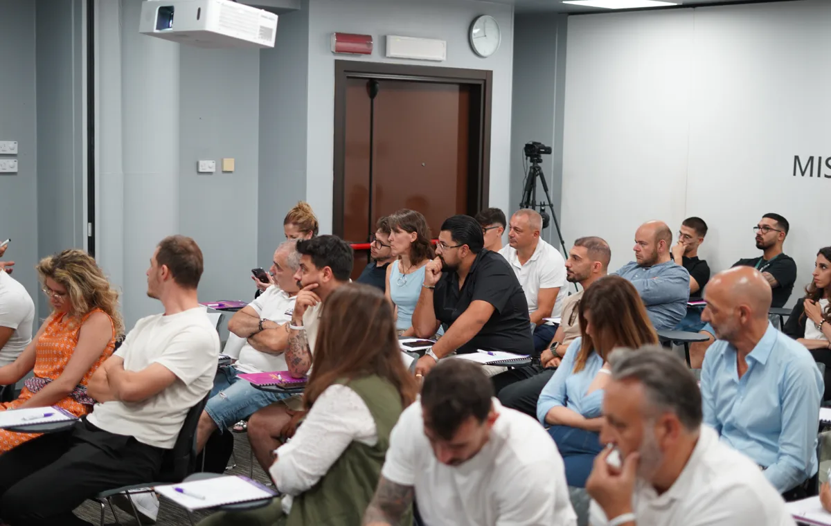 Partecipanti a un evento Venditore di Successo seguono la formazione e prendono appunti in aula